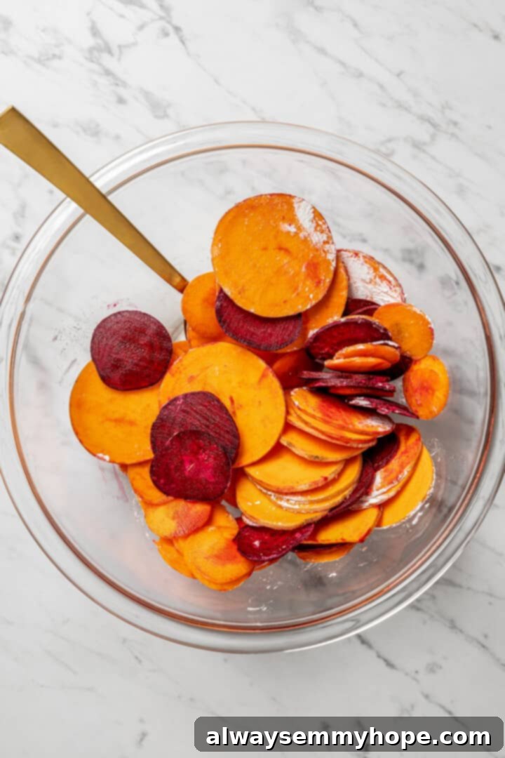 A clear glass bowl containing a vibrant mix of sliced vegetables, thoroughly coated with cornstarch for optimal crispness.