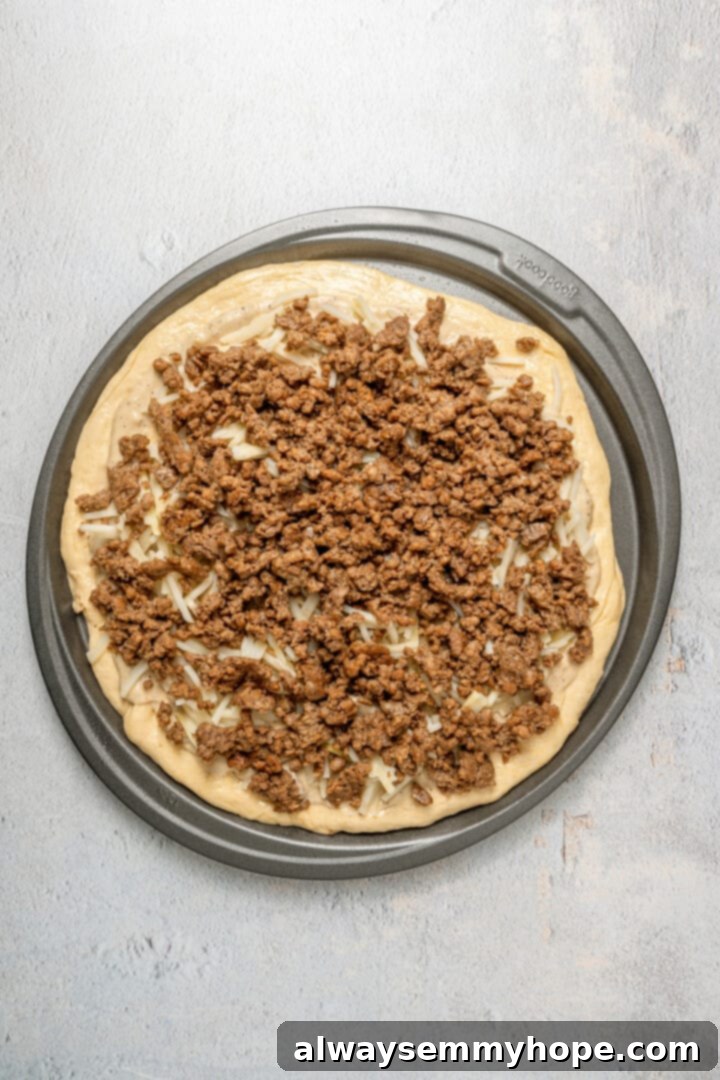 This vegan breakfast pizza features plant-based eggs, cheese, hash browns, and sausage, all baked on a crispy, chewy crust. So good! A vegan breakfast pizza, now additionally topped with cooked and diced vegan sausage over the potatoes and gravy.