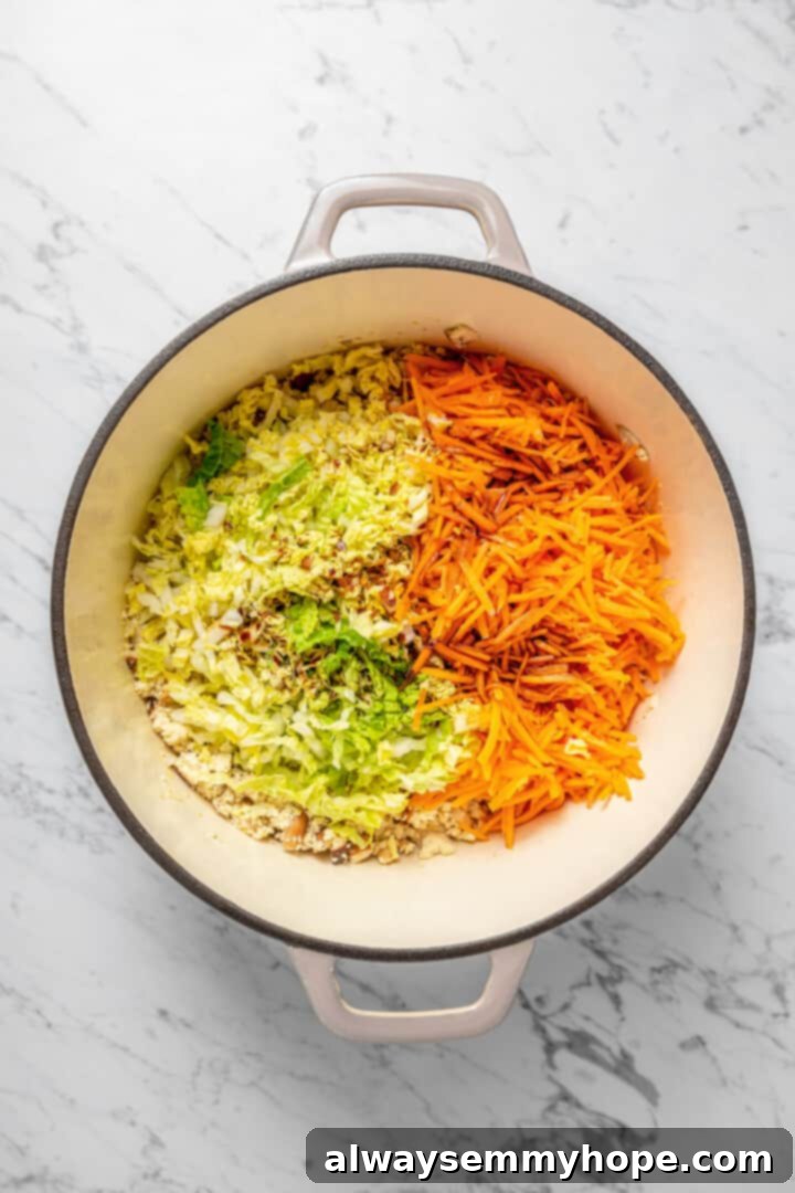 Overhead view of vegetables added to dumpling filling in Dutch oven