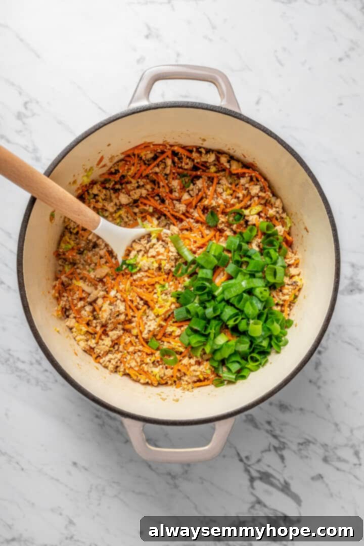 Overhead view of dumpling filling with green onions in Dutch oven