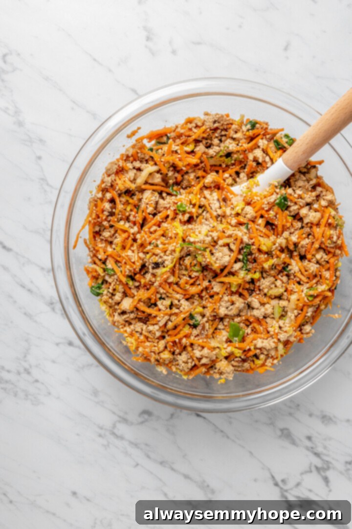 Overhead view of dumpling filling mixture in glass bowl with spoon