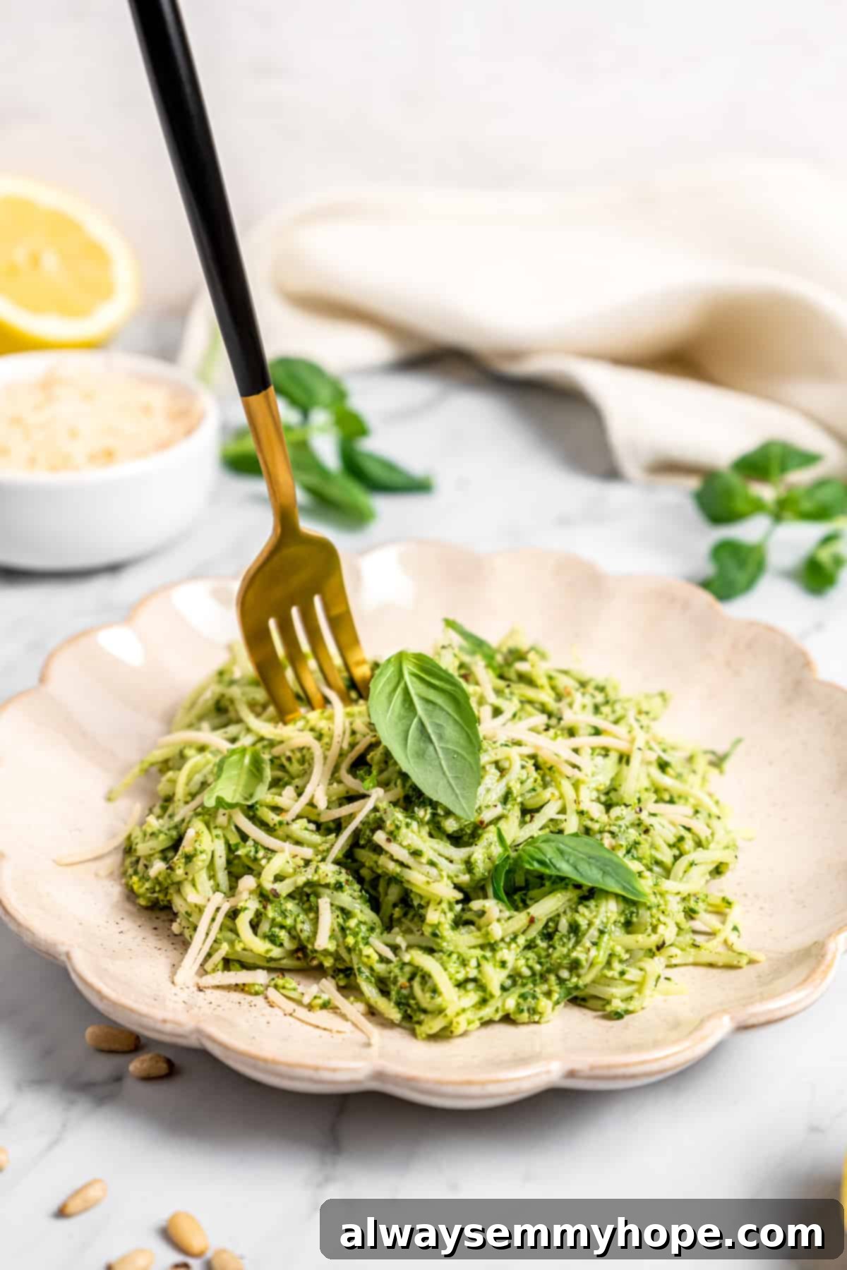 Fork sticking upright in plate of hearts of palm pesto pasta