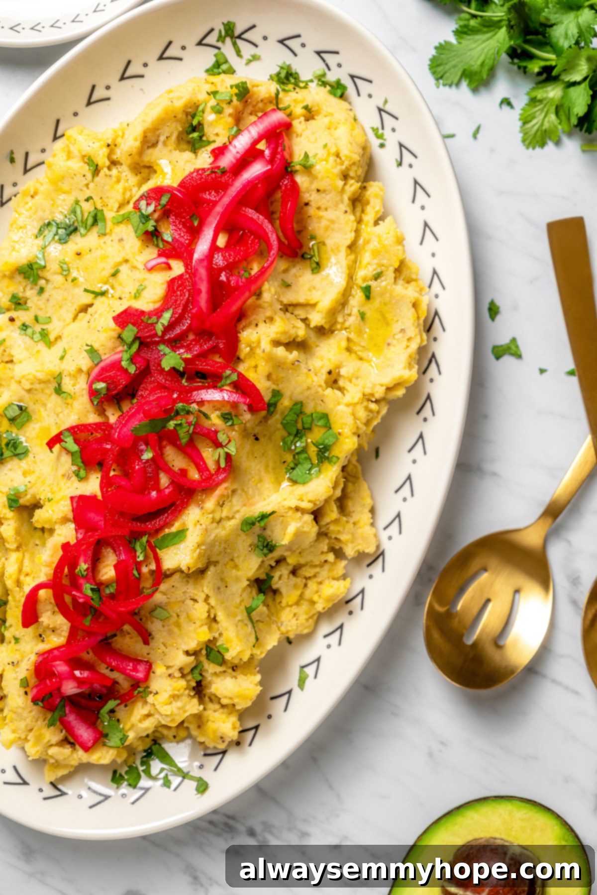 Overhead view of a generous platter of vegan mangú, exquisitely topped with bright pink pickled red onions, creating a stunning presentation.
