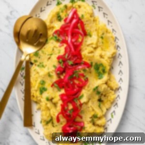 Overhead view of vegan mangú on platter with two serving spoons