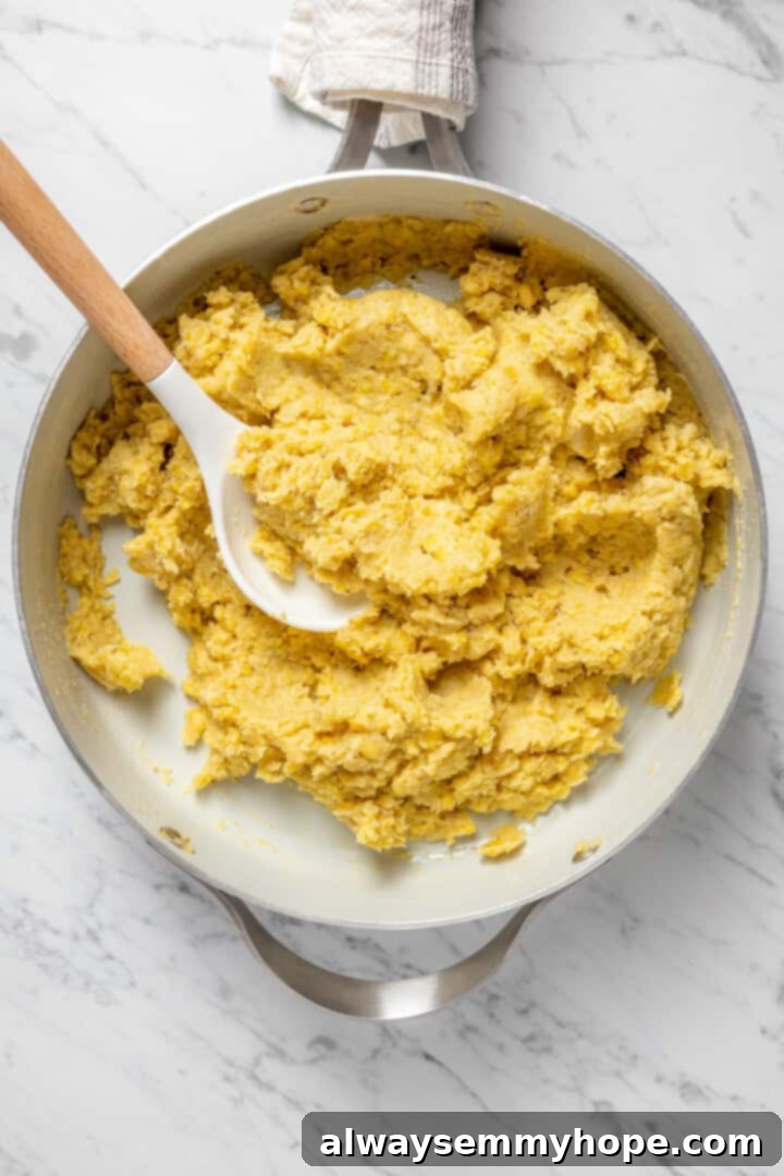 Smooth, creamy vegan mangú in a pot, with a serving spoon resting inside, ready to be dished out.