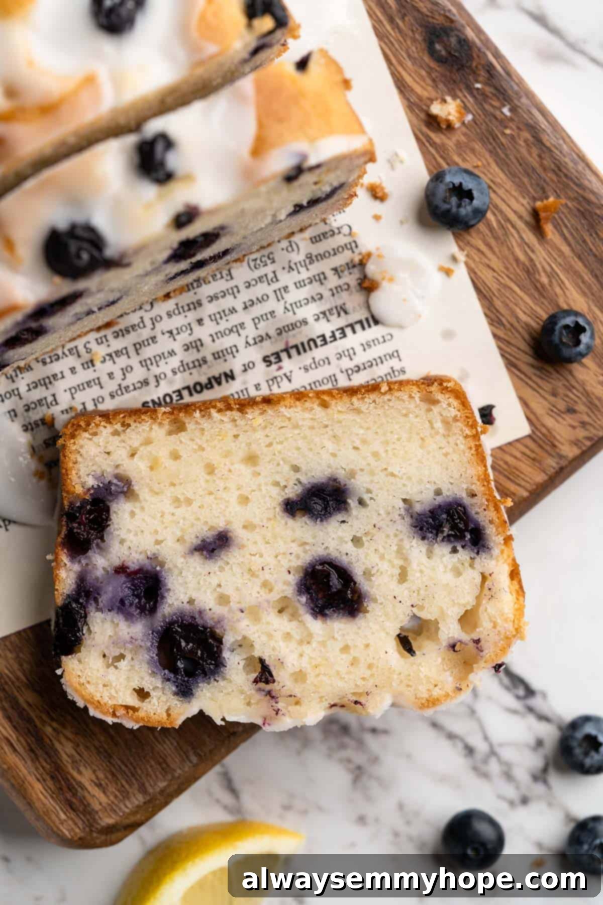 Overhead view of a perfectly moist slice of vegan lemon blueberry bread, showing its tender crumb and juicy blueberries.