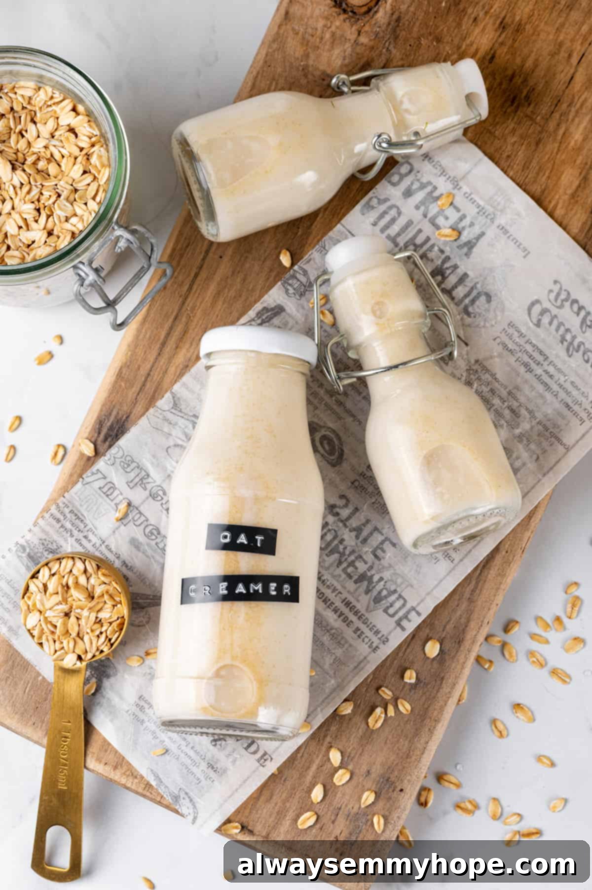 Overhead view of three bottles filled with homemade oat milk creamer, ready for storage and use.
