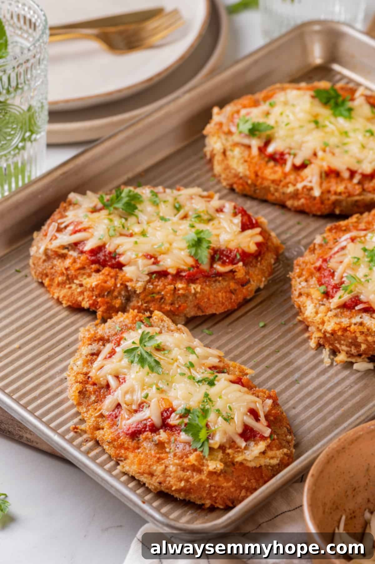 4 chicken parmesan cutlets on baking sheet