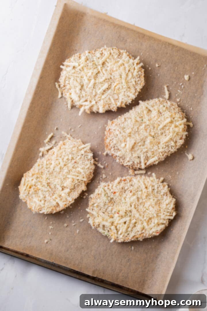 Overhead view of breaded chicken cutlets before cooking