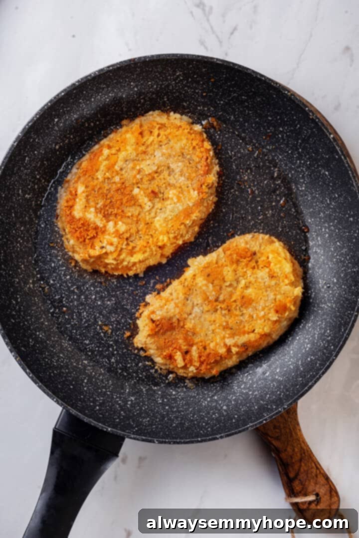 Overhead view of breaded vegan chicken cutlets in skillet