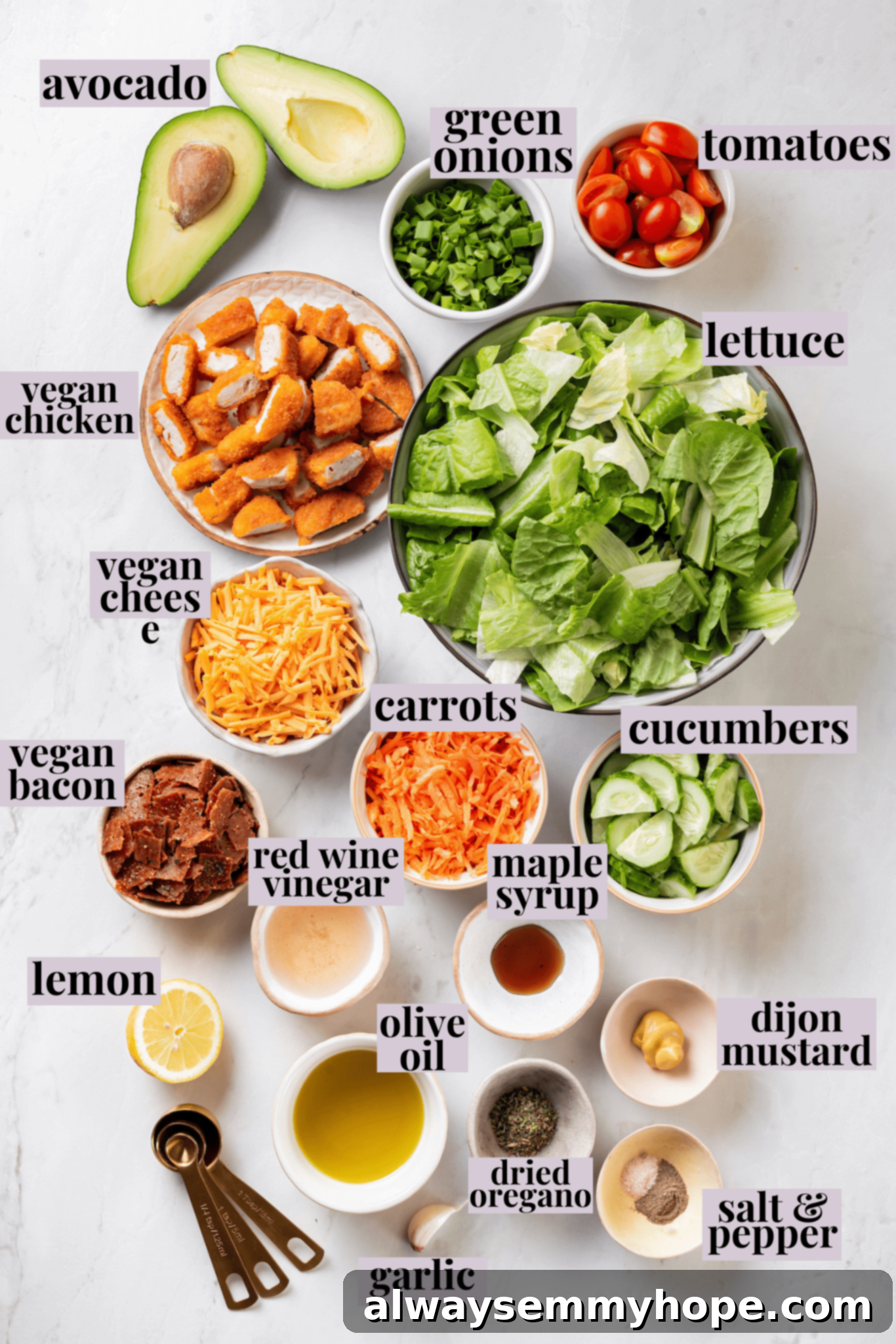 Overhead flat lay of all fresh ingredients for a vegan Chick-fil-A Cobb salad, including various vegetables, vegan cheese, chicken strips, bacon, and dressing components, all neatly arranged with labels.