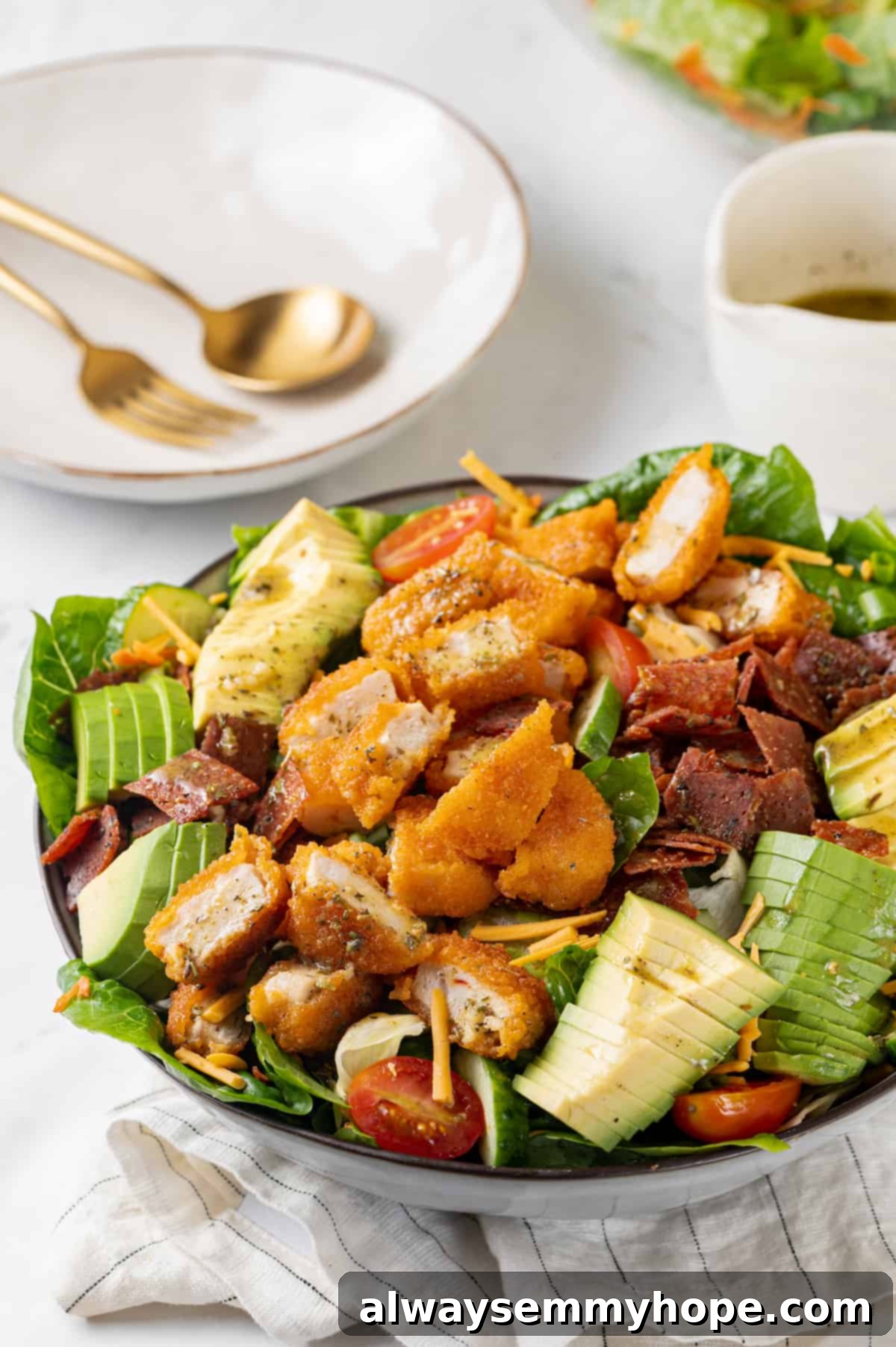 A close-up of a beautifully composed vegan Chick-fil-A Cobb salad in a deep bowl, garnished with fresh herbs and ready to eat. The vibrant colors and textures are prominent.