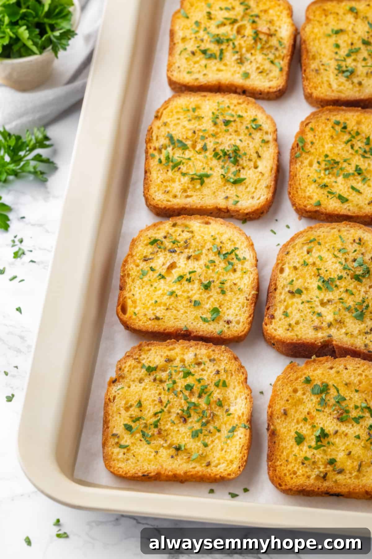Eight slices of perfectly toasted vegan Texas toast arranged neatly on a sheet pan, ready to be served.