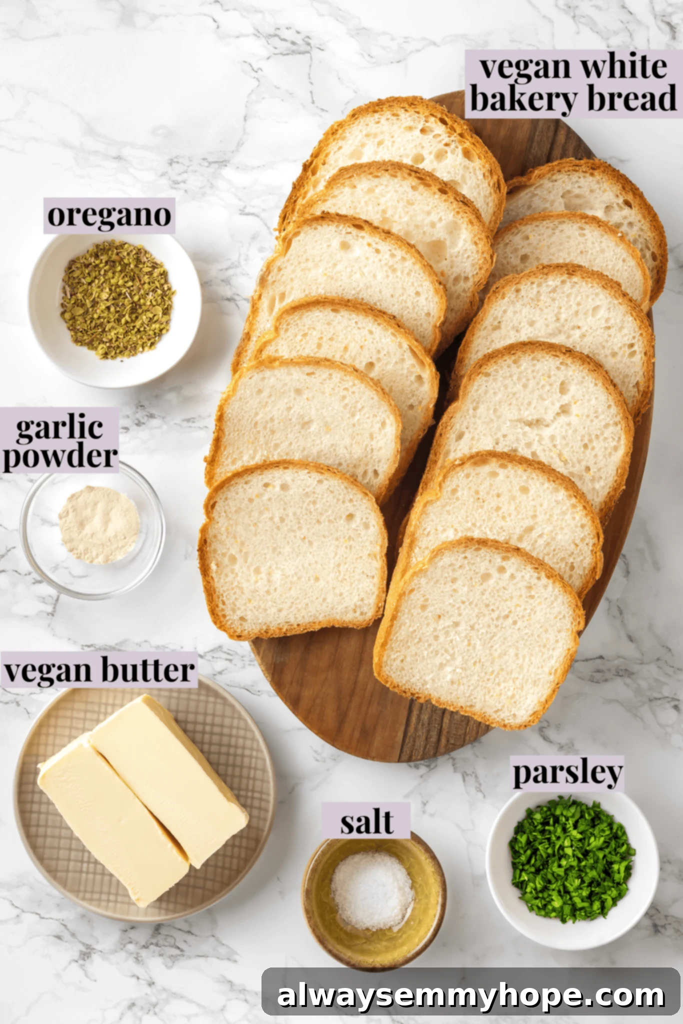 Overhead shot of all ingredients for vegan Texas toast laid out with labels: bread, vegan butter, garlic powder, oregano, salt, and fresh parsley.