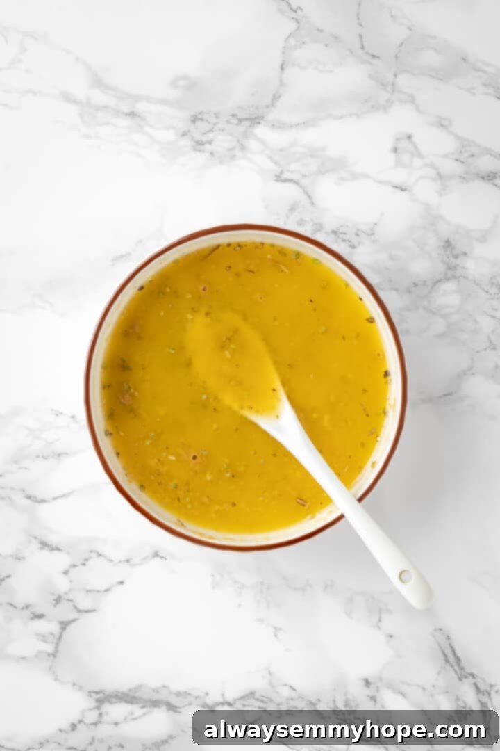 Overhead view of the garlic butter mixture in a small white bowl with a spoon, perfectly combined and ready to use.