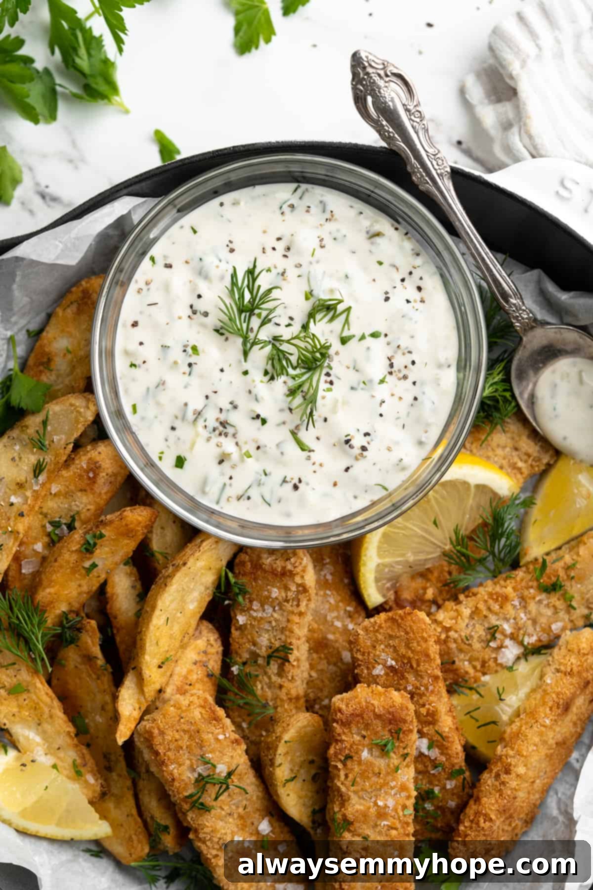 Overhead view of vegan tartar sauce in bowl with vegan fish and chips