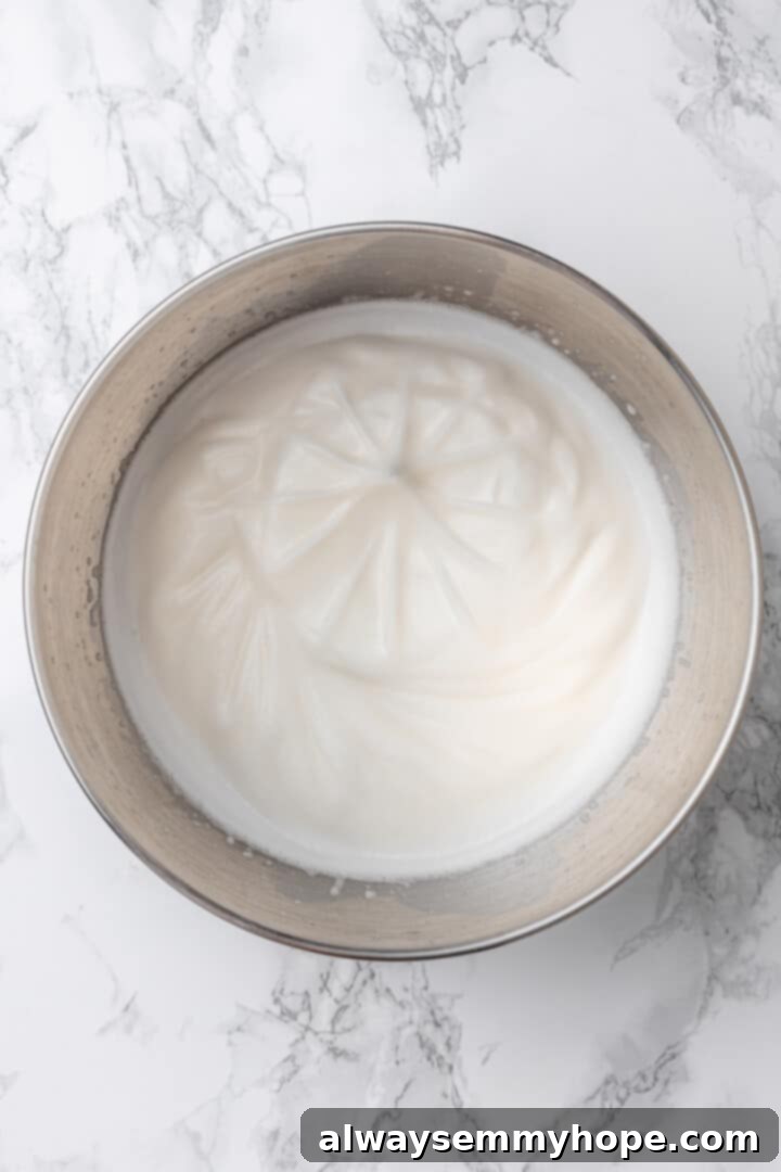 Overhead view of whipped aquafaba in mixing bowl