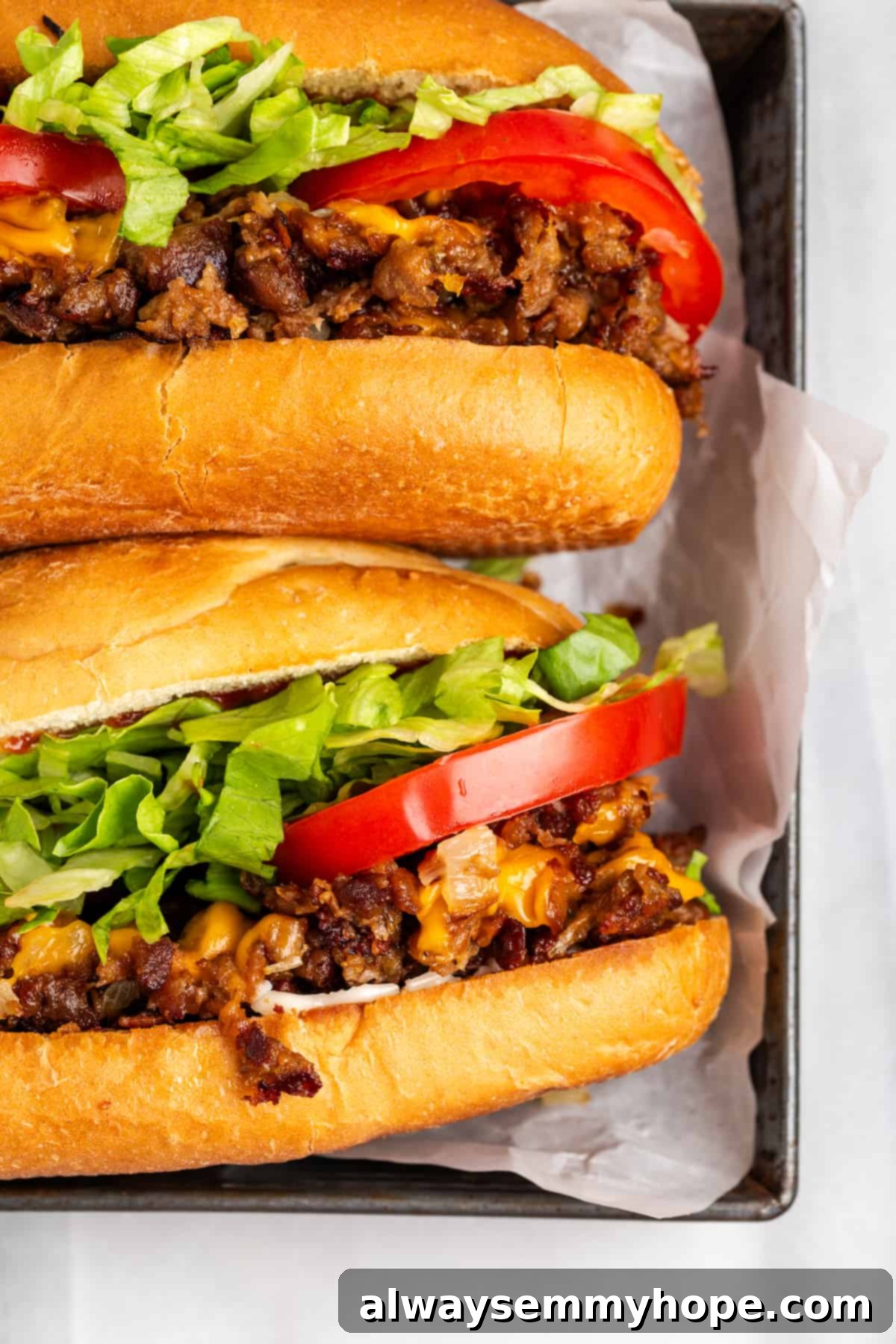 The chopped cheese sandwich is a NYC classic—and now you can make your own vegan version at home! You'll love this easy, delicious recipe. Top view of two vegan chopped cheese sandwiches on hoagie rolls