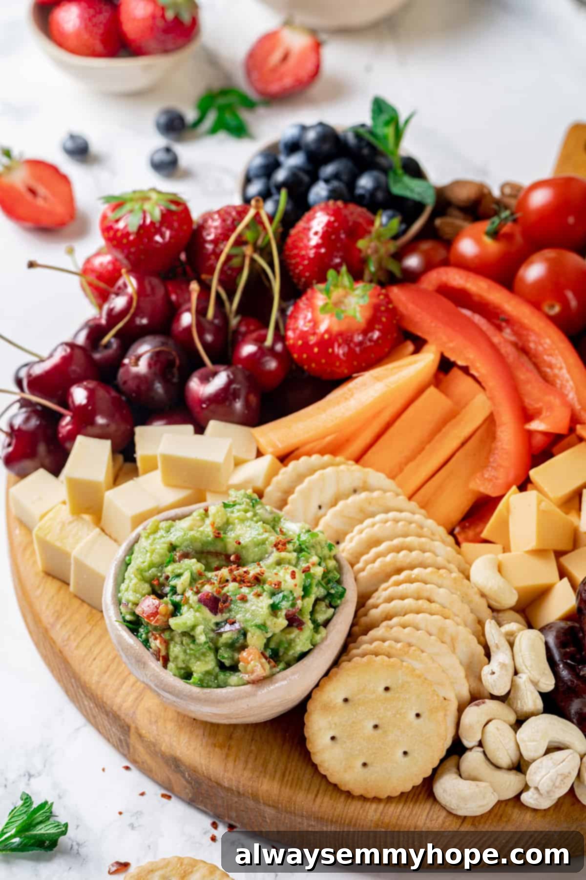 A completed Vegan charcuterie board, filled to the brim with plant-based cheeses, olives, nuts, a colorful assortment of fruits and vegetables, creamy guacamole, and various crackers.