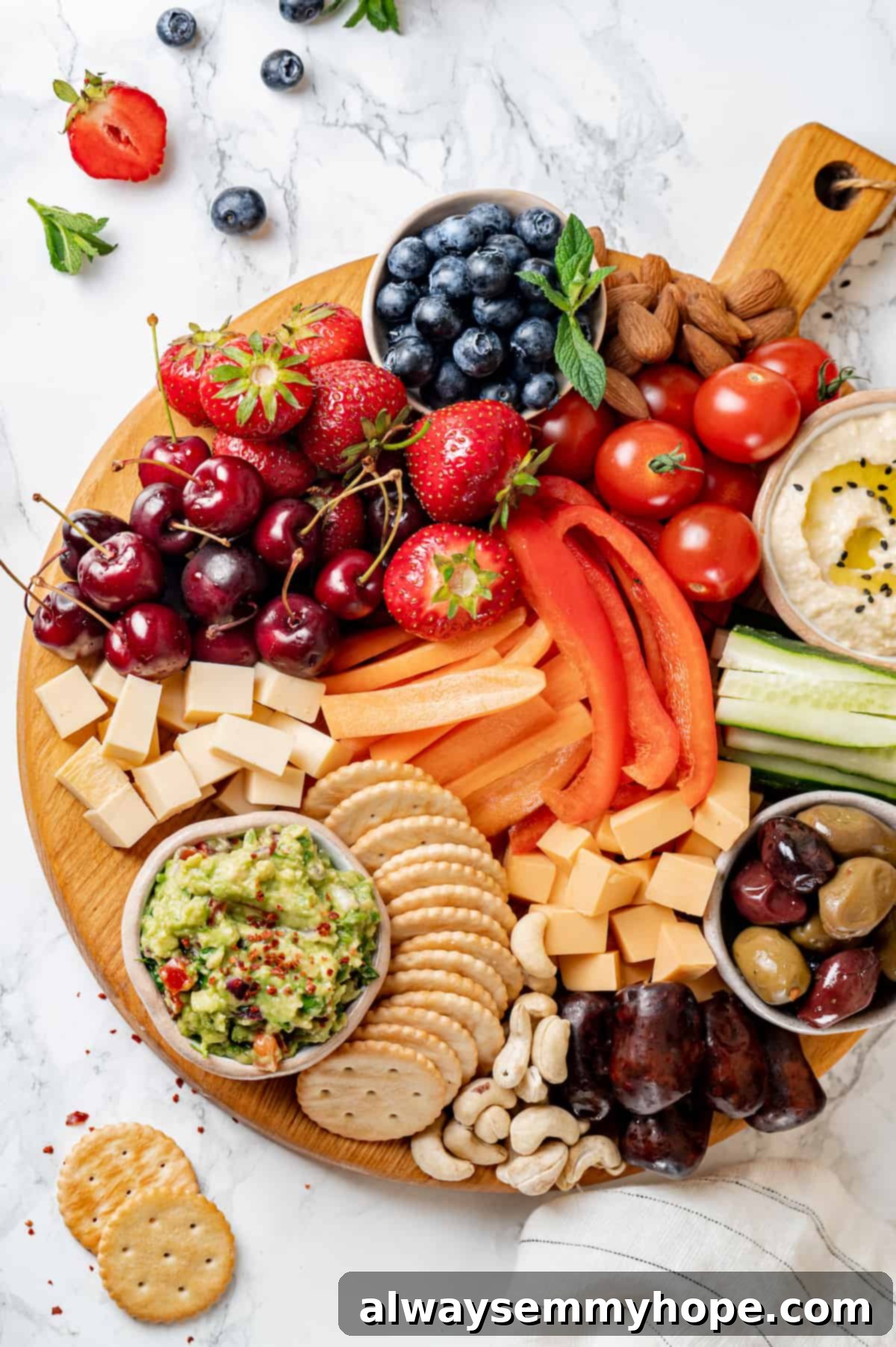 Overhead view of a perfectly arranged Vegan charcuterie board, featuring a balanced display of plant-based cheese, various olives, mixed nuts, fresh and dried fruits, and colorful vegetables.