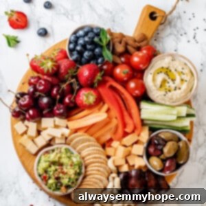 Overhead view of Vegan charcuterie board with cheese, olives, nuts, fruits, and veggies