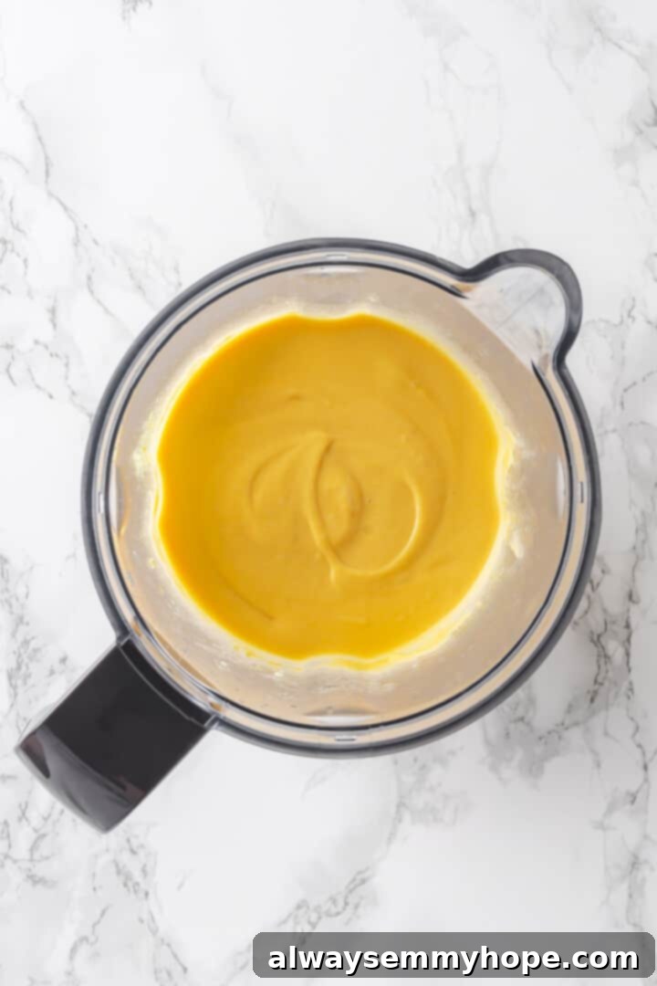 The smooth, creamy vegan cheese sauce blended in a high-speed blender jar.