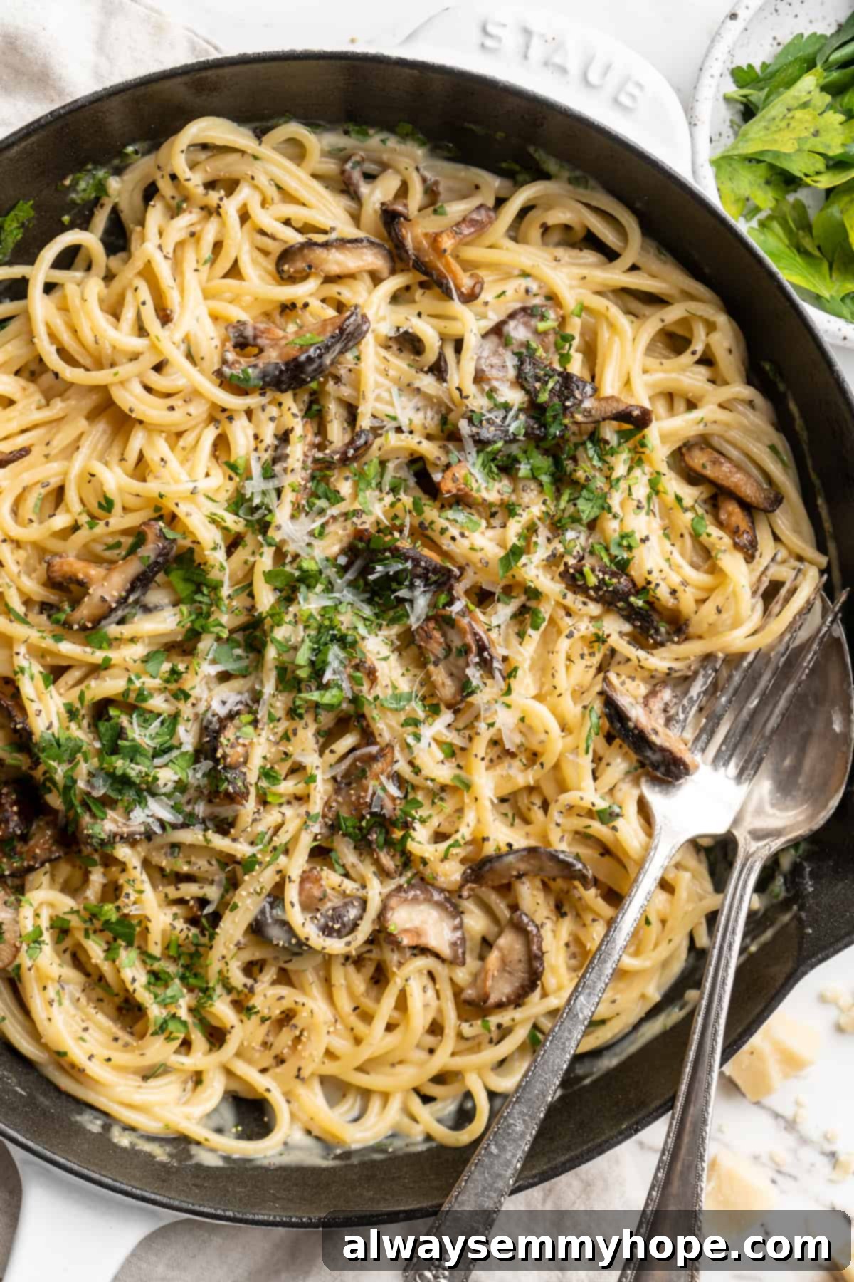 Overhead view of miso butter pasta in skillet with fork and spoon, ready to be served.