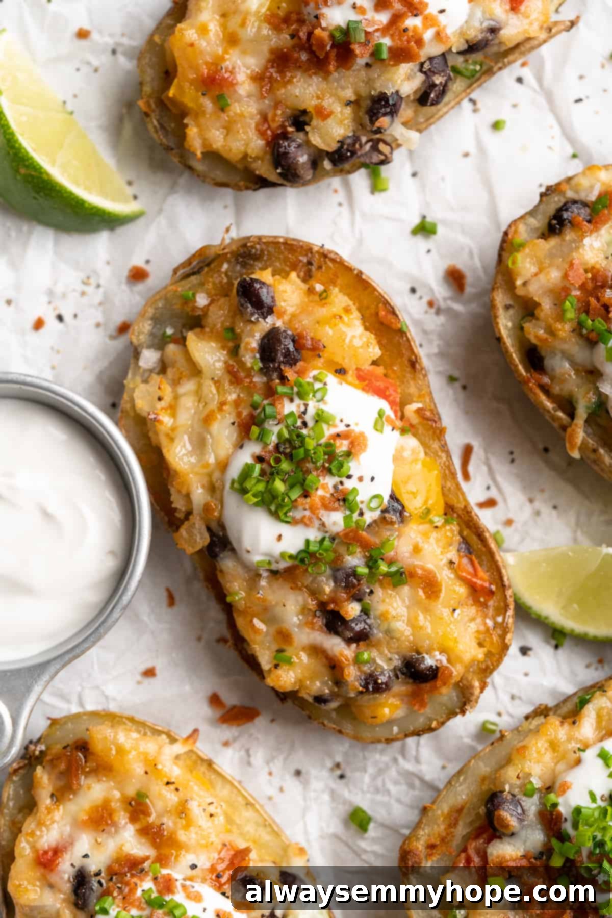 Overhead view of loaded potato skin topped with chives, vegan bacon, and sour cream