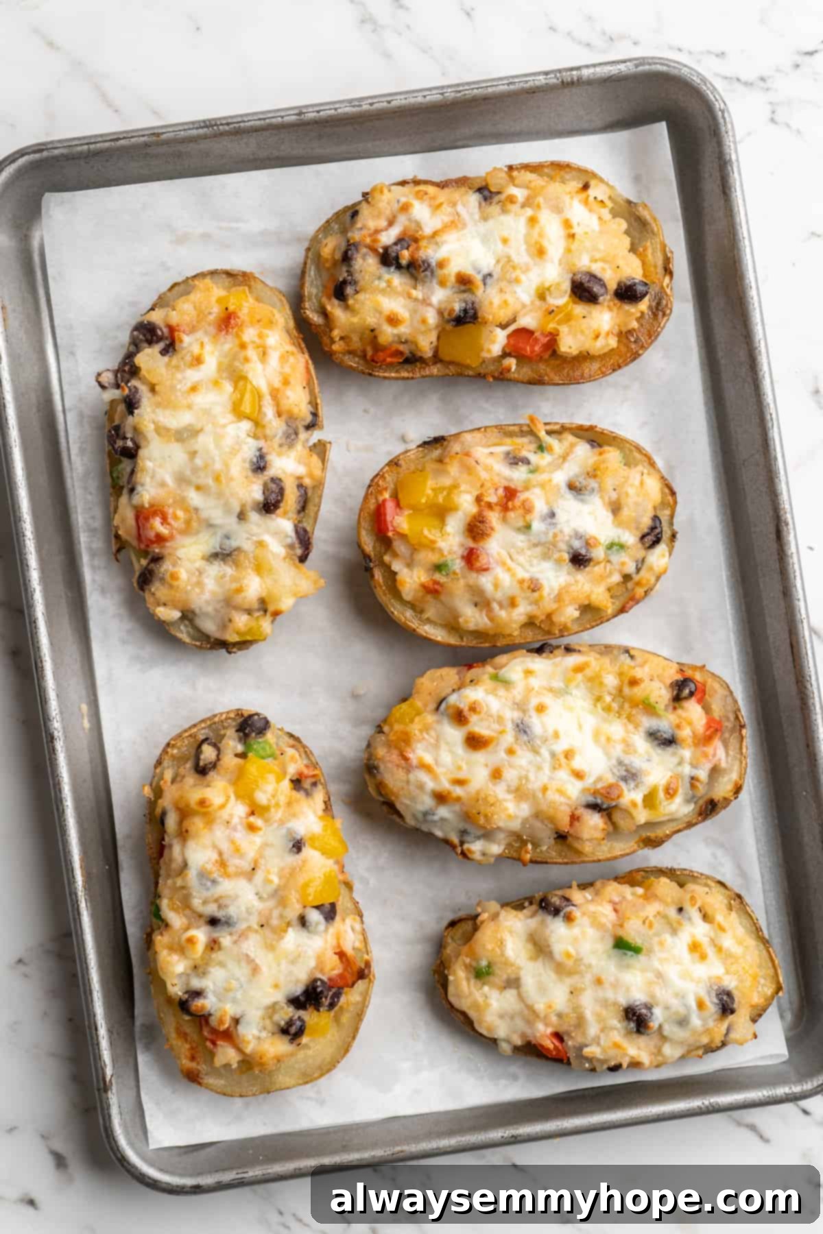 Overhead view of vegan loaded potato skins on parchment-lined baking sheet