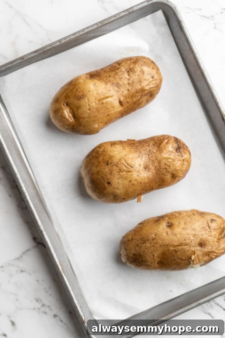 Overhead view of whole potatoes on parchment-lined baking sheet