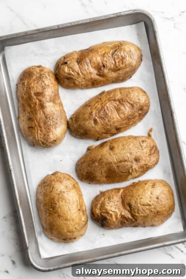 Overhead view of upside down potato halves on parchment-lined baking sheet