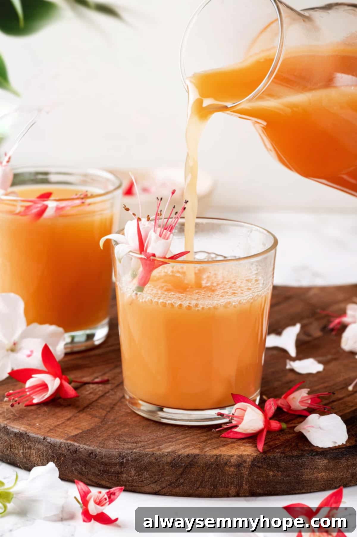 Pouring POG juice from a carafe into a small juice glass