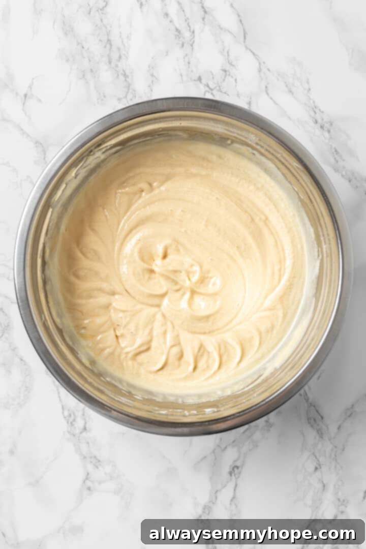 An overhead shot of the rich peanut butter ice cream base mixture in a bowl, showcasing its smooth and inviting texture.