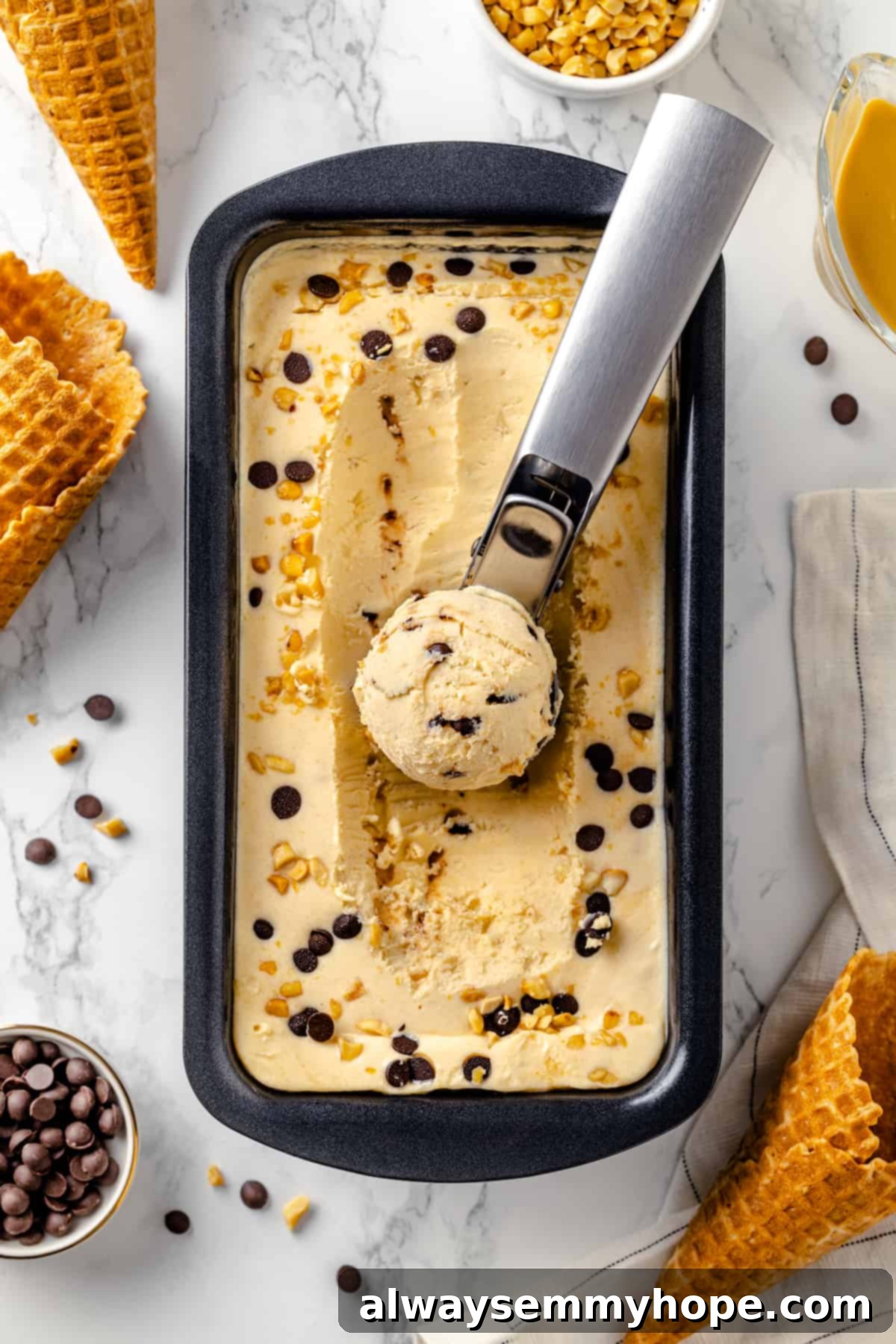 A scoop of creamy no-churn peanut butter ice cream being served from a loaf pan, showing its perfect texture.
