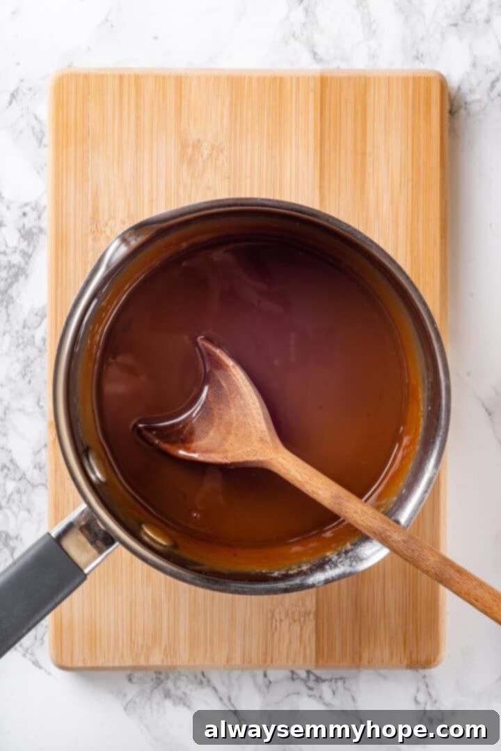 Melting Vegan Caramel for Carmelitas Overhead view of smooth, melted vegan caramel sauce in a saucepan with a wooden spoon