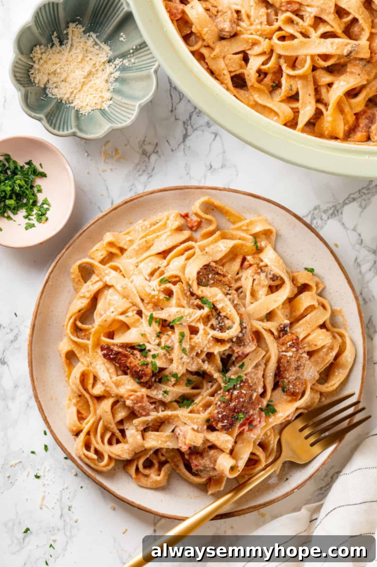 Overhead view of vegan Cajun chicken pasta on plate with gold fork, ready to be eaten