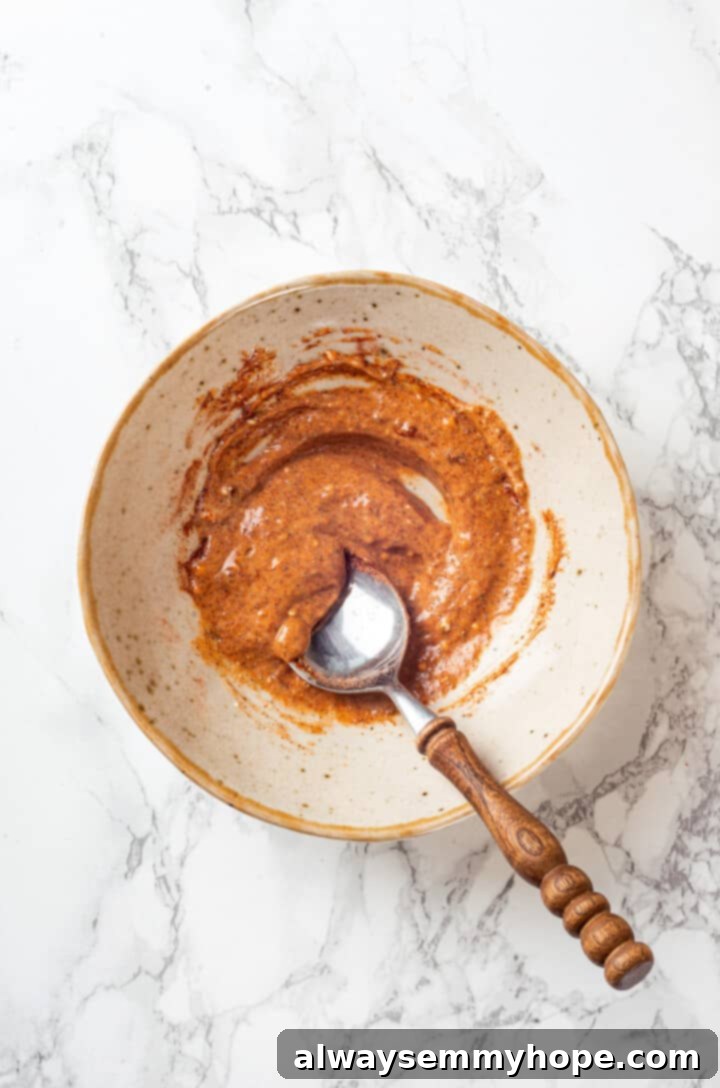 Overhead view of marinade for chicken in a mixing bowl with a spoon