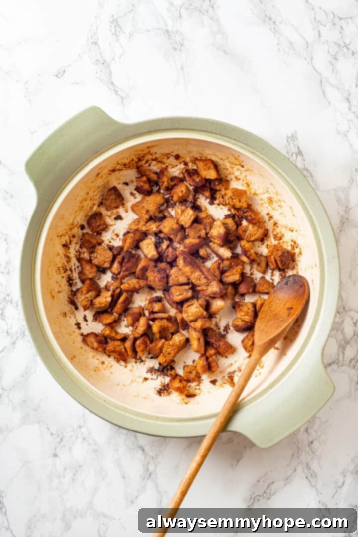 Overhead view of vegan chicken searing in a hot skillet with olive oil