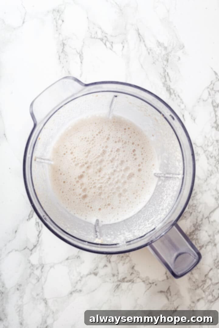 Overhead view of blended cashew cream in a blender, perfectly smooth