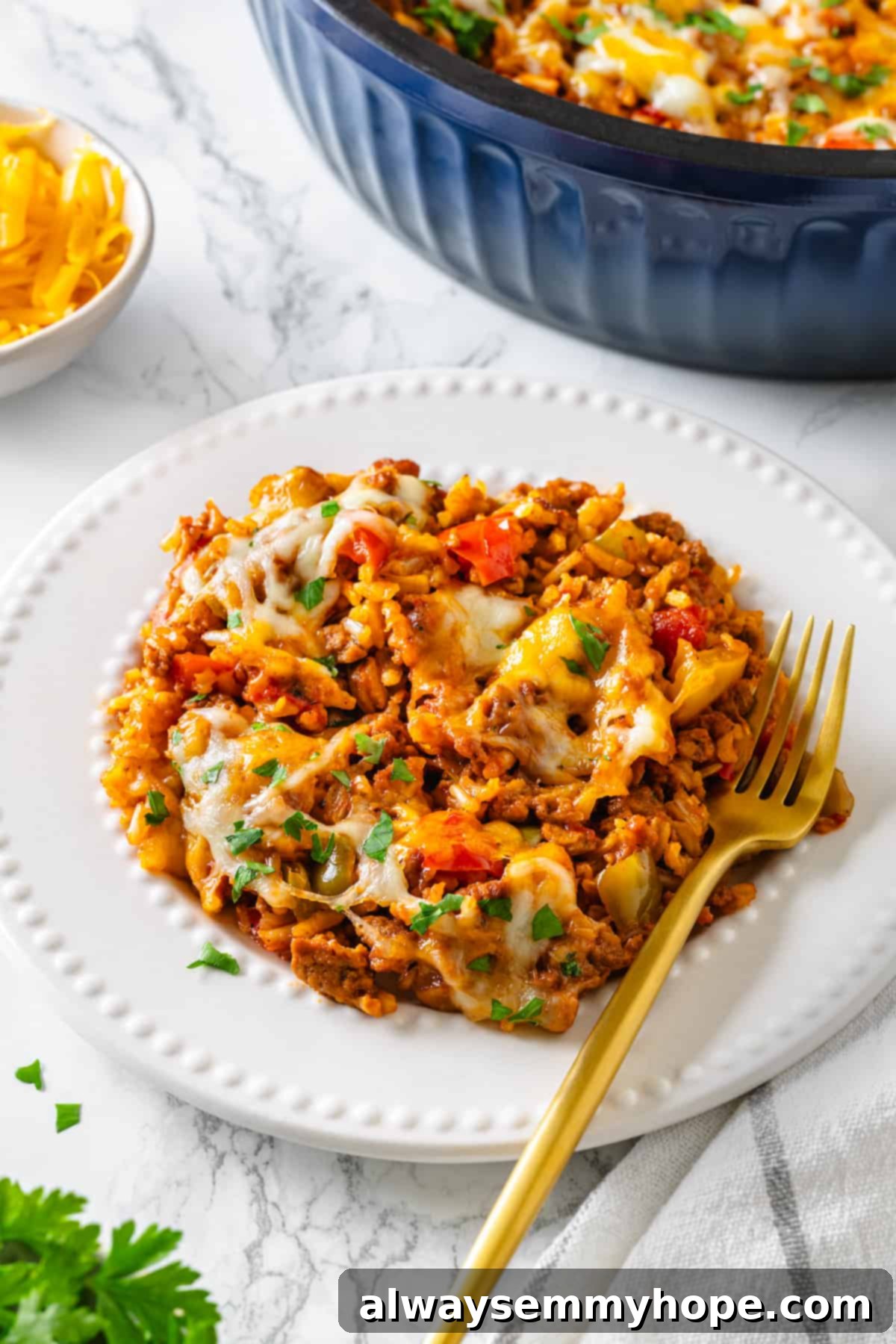 A serving of vegan stuffed pepper casserole with a gold fork on a white plate. Vegan stuffed pepper casserole on white plate with gold fork