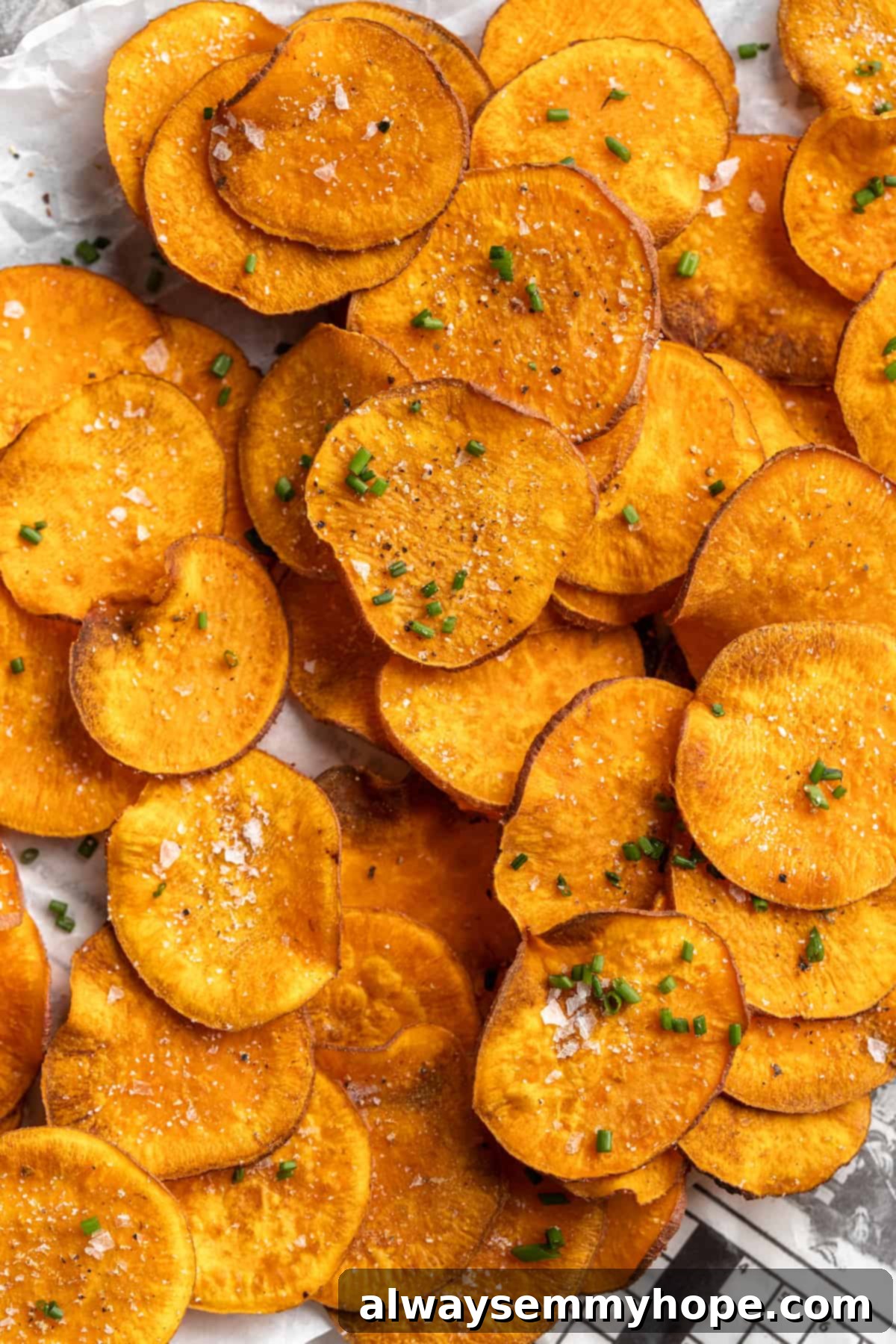Once you start eating these crispy homemade sweet potato chips, you won’t be able to stop! Super easy to make with only 3 ingredients. A generous pile of crispy homemade sweet potato chips, perfectly golden and seasoned with sea salt