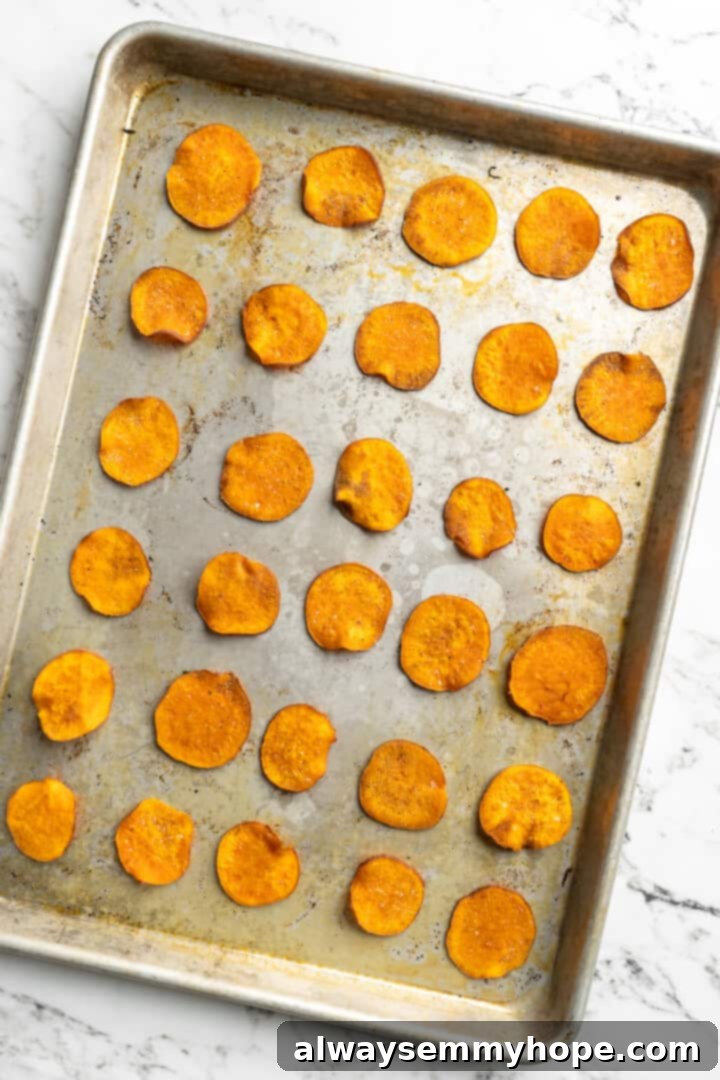 Once you start eating these crispy homemade sweet potato chips, you won’t be able to stop! Super easy to make with only 3 ingredients. Overhead view of golden-brown, crispy sweet potato chips fresh out of the oven on a baking sheet