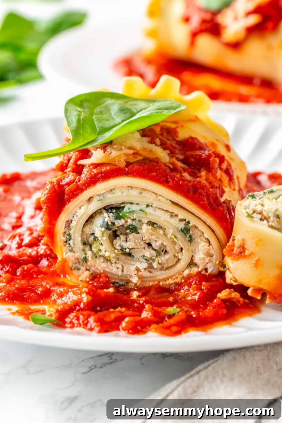 Close-up shot of a single vegan lasagna roll on a white plate, garnished with a fresh basil leaf, showcasing its delectable layers.