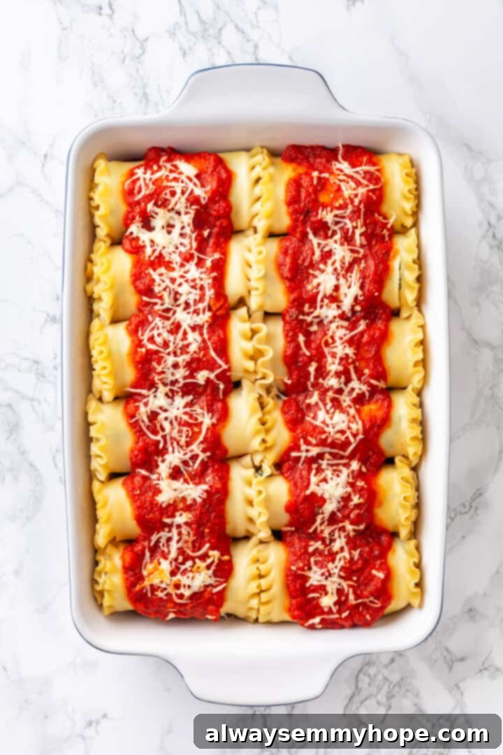 Overhead shot of freshly baked vegan spinach ricotta lasagna rolls in a casserole dish, bubbling and golden brown.