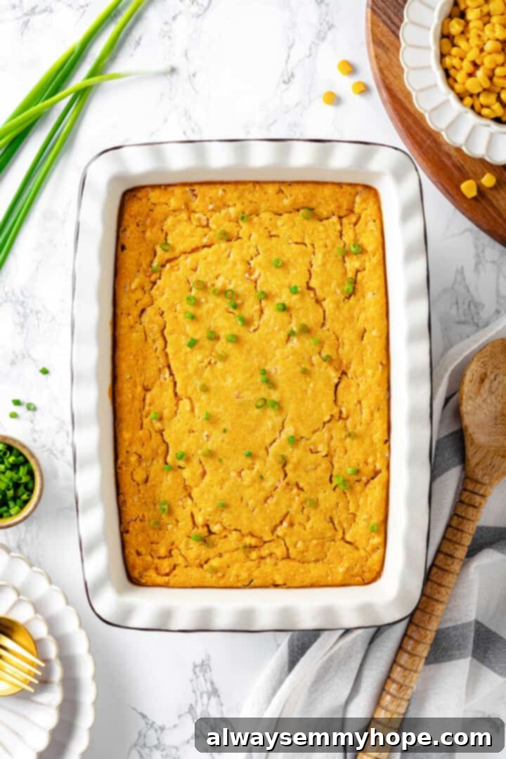 Overhead view of a perfectly baked vegan cornbread pudding in a white baking dish, fresh from the oven and ready for garnishing.