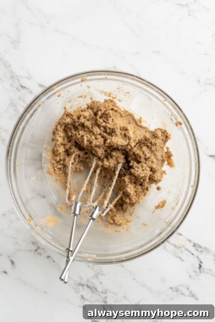 Overhead view of creamed vegan butter and brown sugar in a mixing bowl, light and fluffy