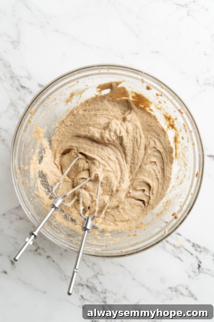 Overhead view of wet ingredients for vegan oatmeal cookies (creamed butter, sugar, flax egg, vanilla) in bowl