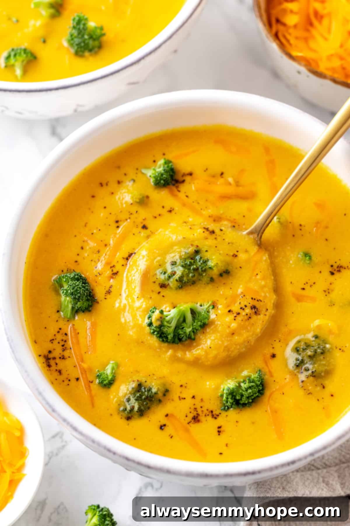 Overhead view of a rich, creamy vegan broccoli cheddar soup in a bowl with a spoon, showcasing its delectable texture. Overhead view of a rich, creamy vegan broccoli cheddar soup in a bowl with a spoon, highlighting its comforting texture.