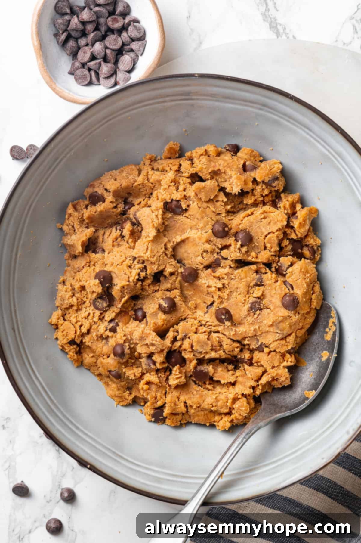 Overhead view of protein cookie dough in bowl with spoon