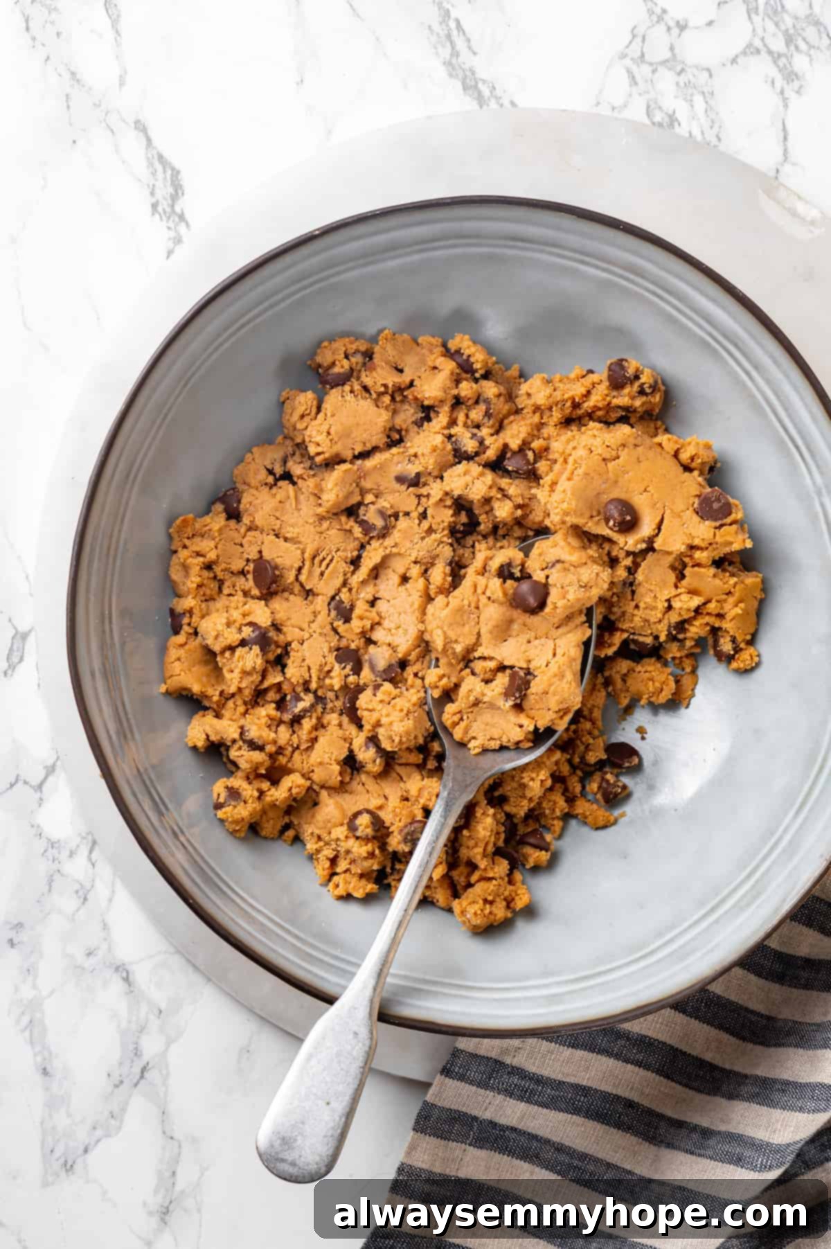 Overhead view of protein cookie dough in mixing bowl with spoon